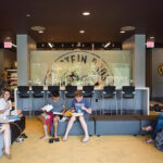 Students sit in cafe common area on campus.