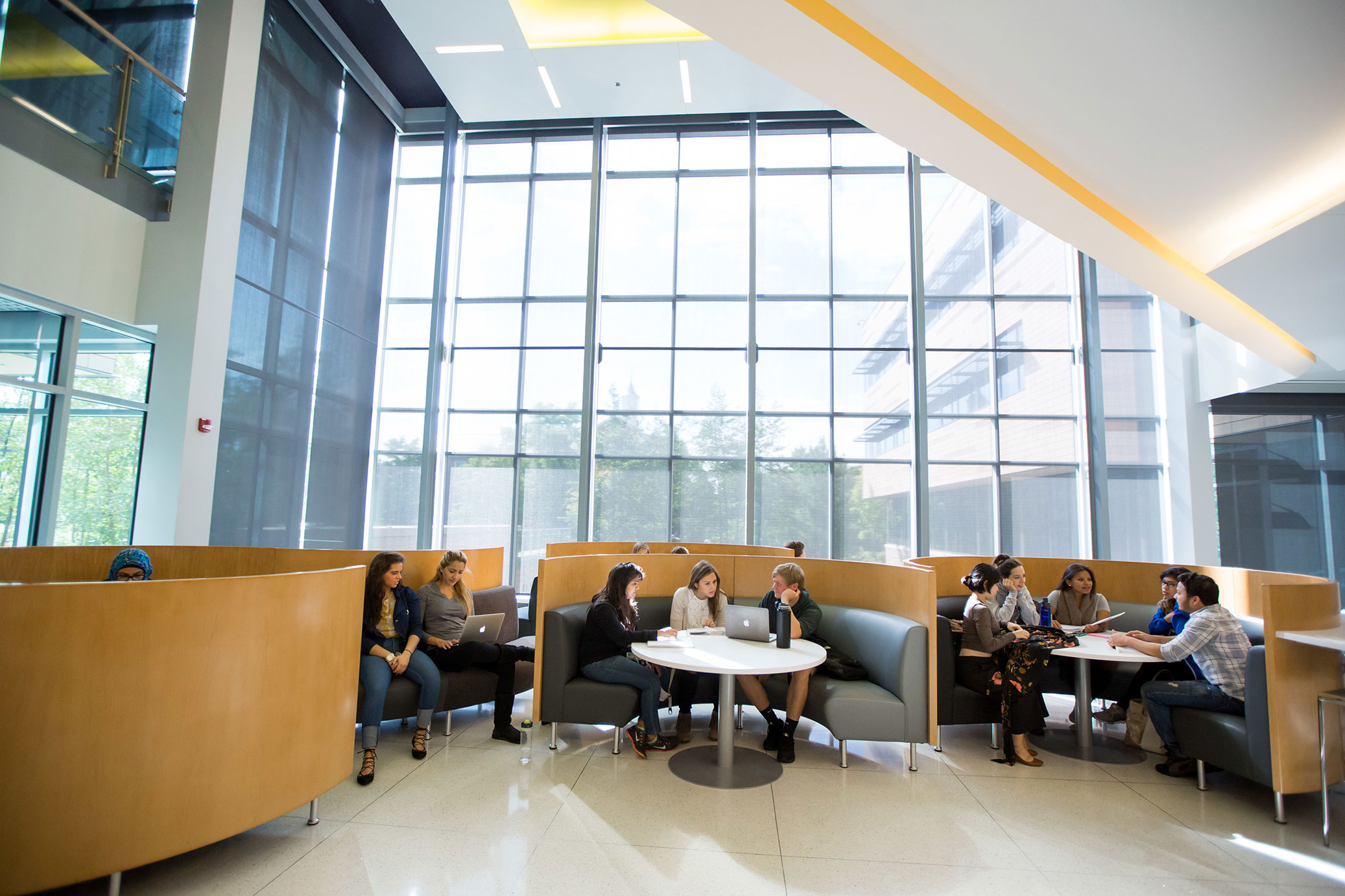 Students sitting by tables in the Johnson Center Lobby