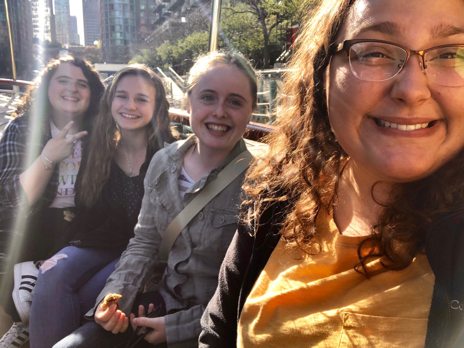 Four young women smiling while riding a water taxi, downtown Chicago