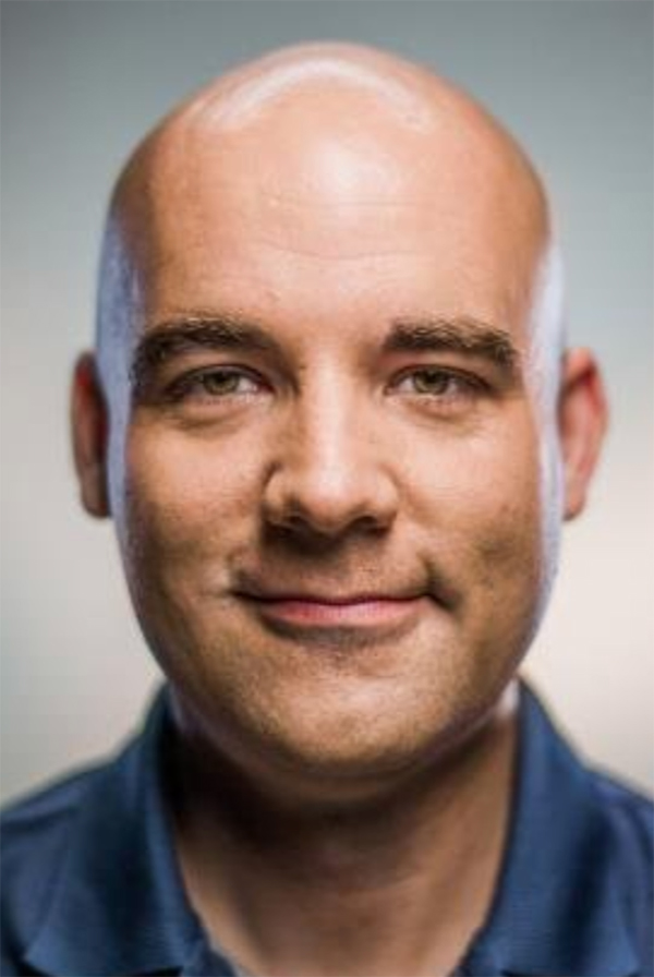 Smiling man in blue collared shirt