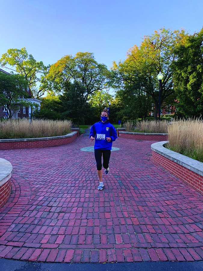 Woman in blue NPU hoodie running through campus.