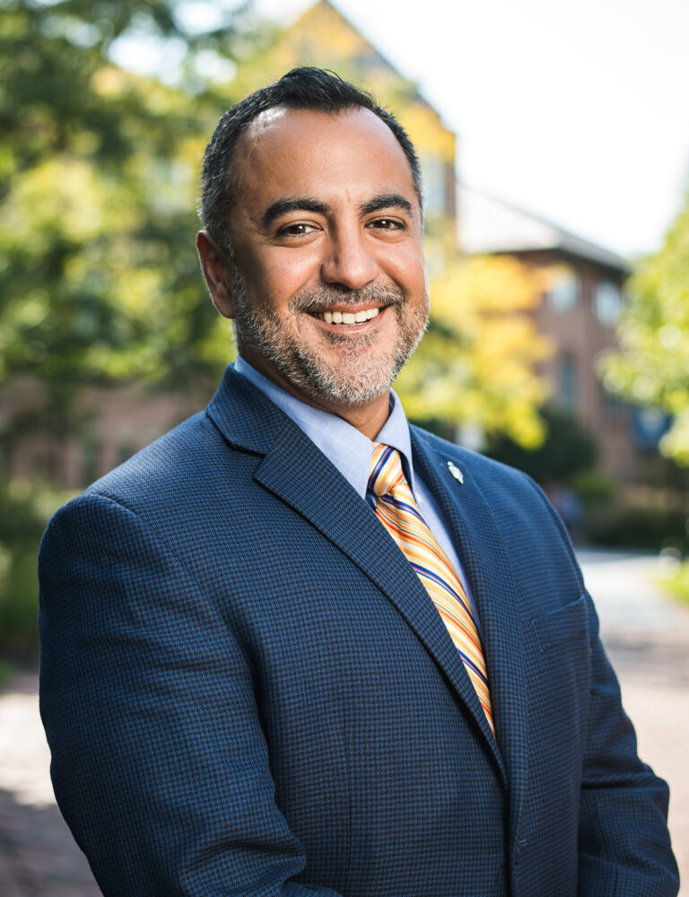 Man in navy suit and gold tie