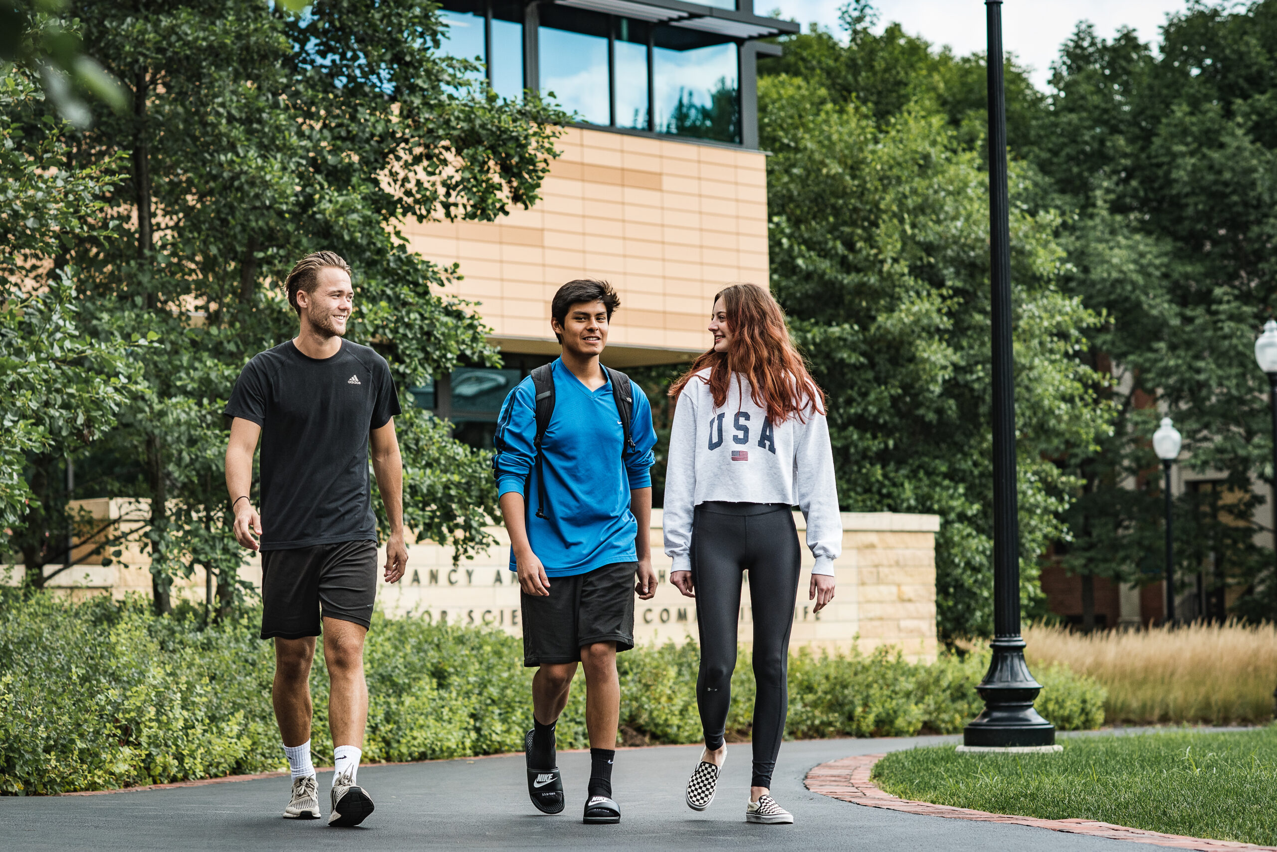 Three students walking together outside of the Johnson center