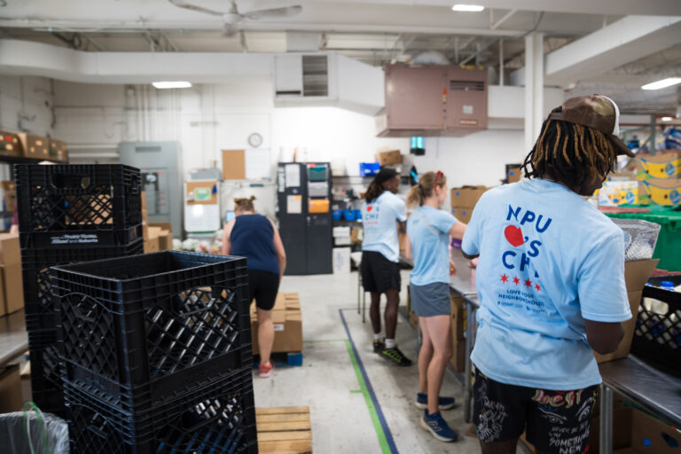 ýers volunteer at a food pantry.