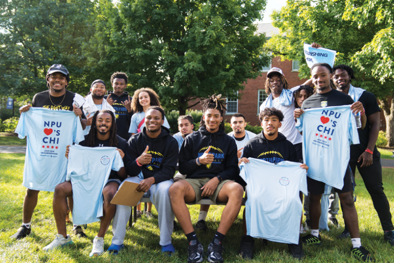 North Park students and volunteers holding up their Service Day t-shirts and smiling