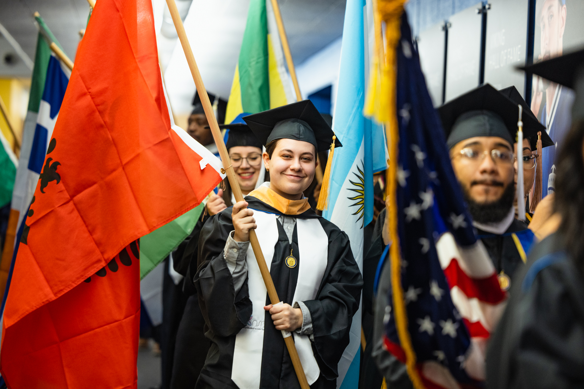North park graduates walking down hallway with processional flags